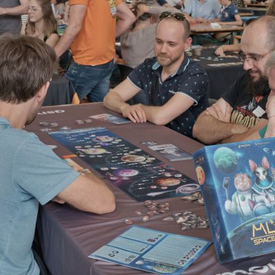 Groupe de visiteurs jouant au jeu de société MLEM Space Agency